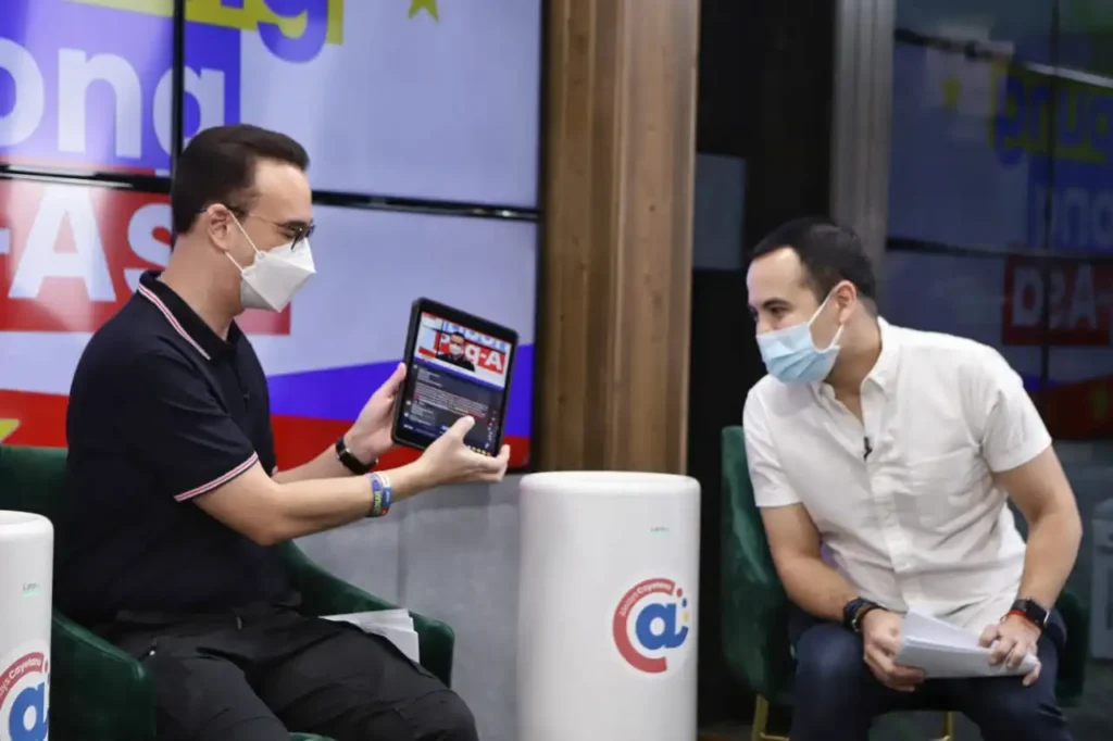 Former House Speaker Alan Peter Cayetano (with host Andrei Felix at right) selects beneficiaries from the Facebook live comments section.