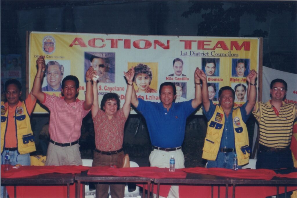 Alan Peter Cayetano, with the "Action Team," raises hands in unity, campaigning for 1st District Councilors, showcasing political alliance.