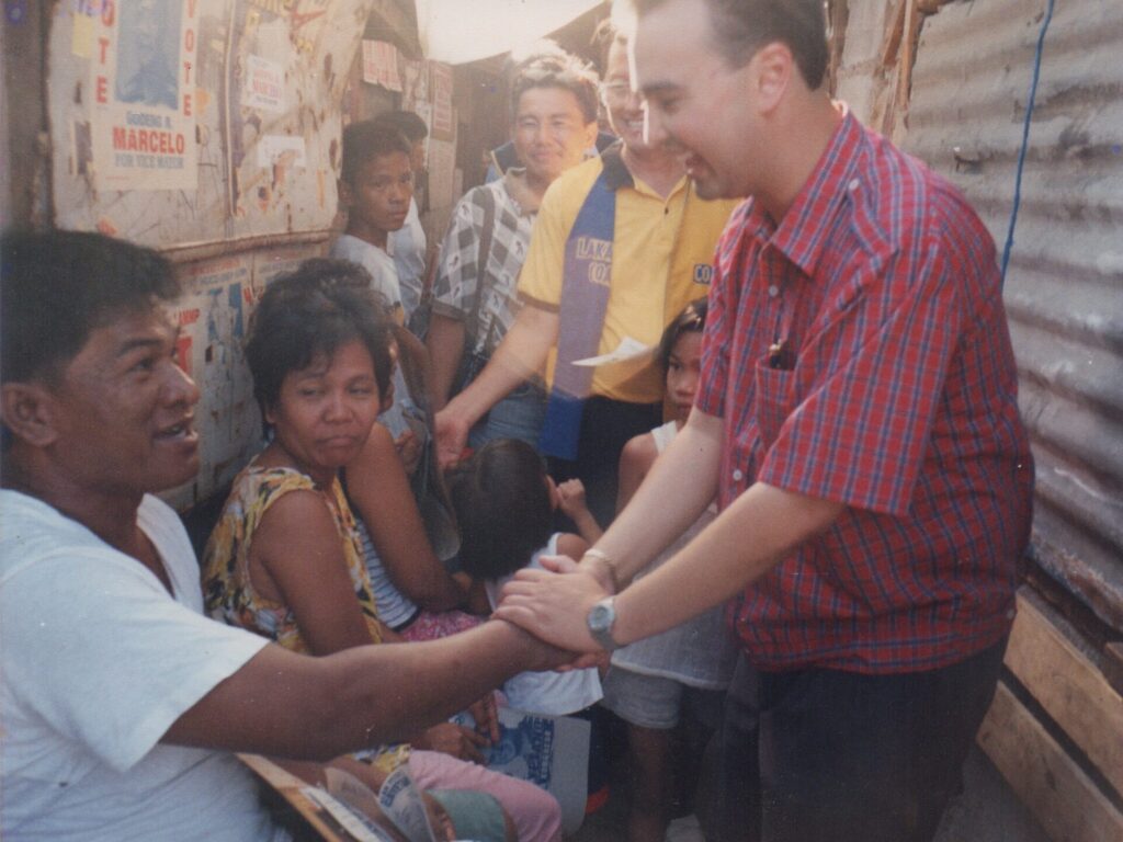 Alan Peter Cayetano engages with residents in a community, possibly during outreach or campaign, showing interaction with locals.